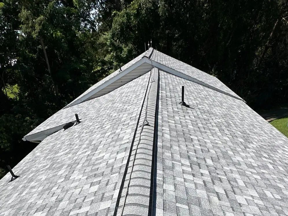 The same ridge in new gray architectural shingles with a new ridge vent and black roof vents