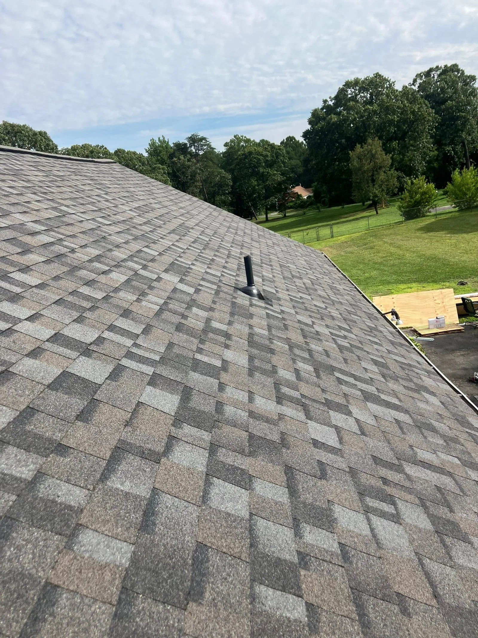 Completed architectural shingle roof with a new pipe boot set into the field