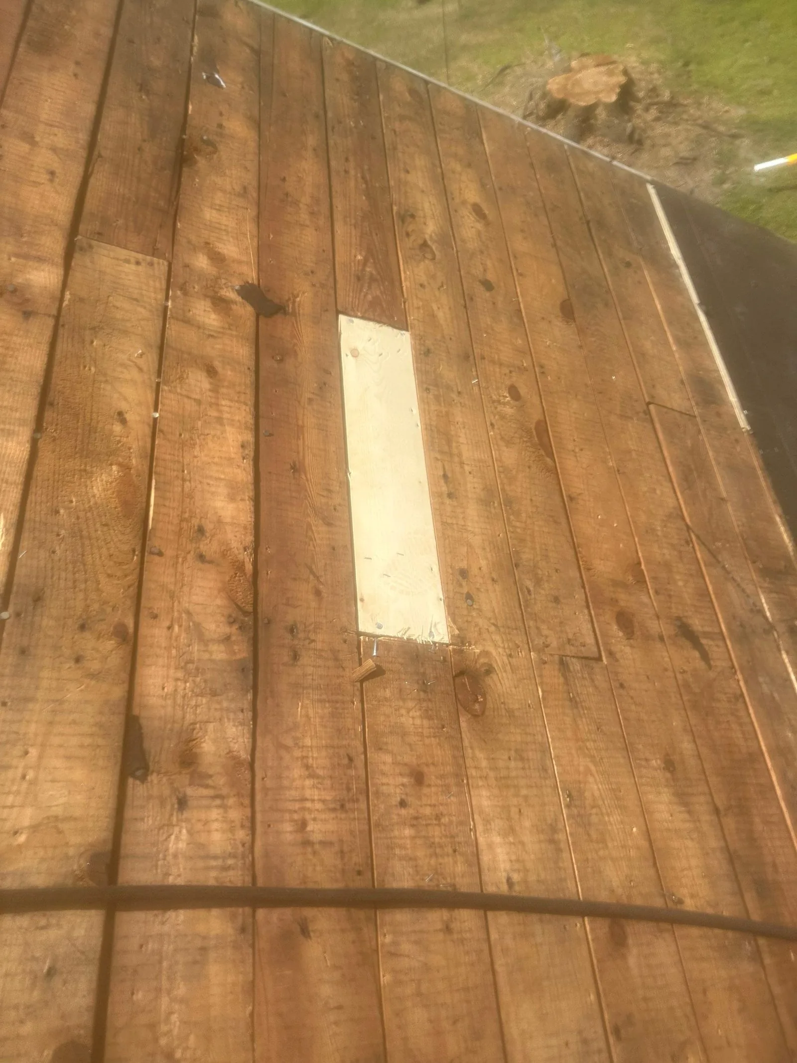 One bright new replacement board let in among the weathered plank decking